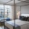 bedroom with large window and four post bed